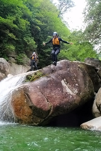 Jumping off rocks into a river during our Japan adventure climbing waterfalls.