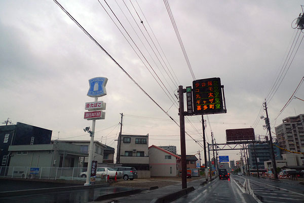 Picture of a street and convenience store in Japan during rainy season.